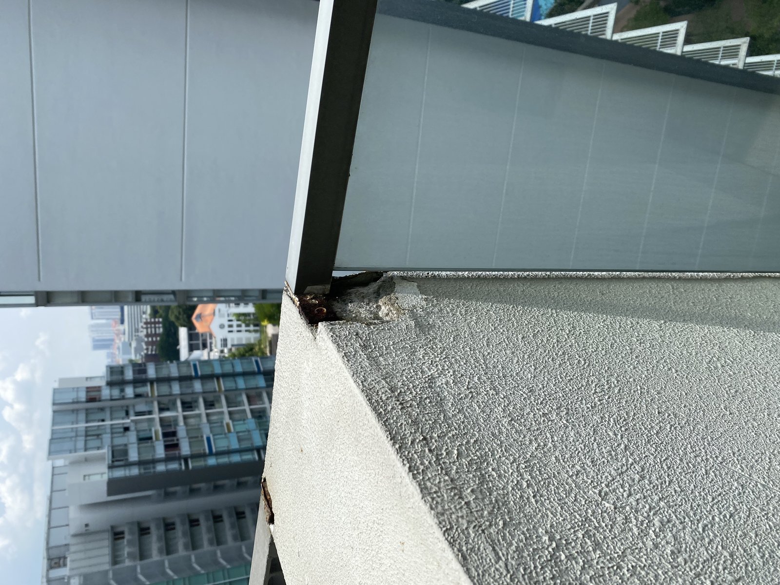 Structural damage and rust at balcony railing documented in property condition report